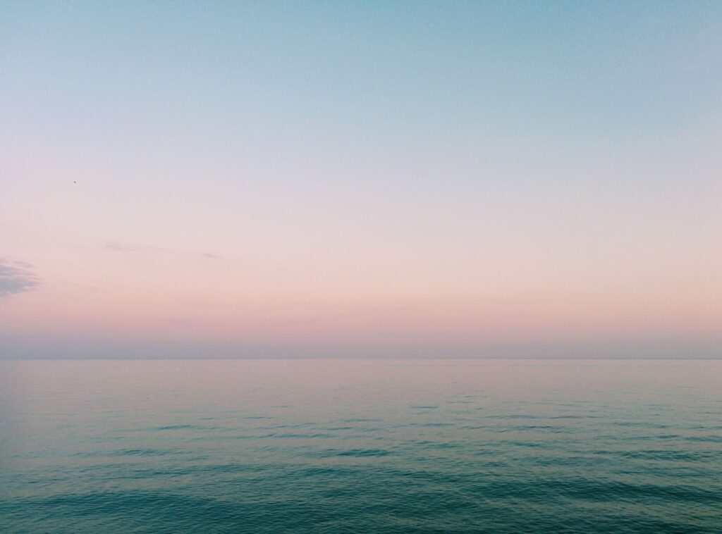 Pastel colored pink and blue sunset over open water