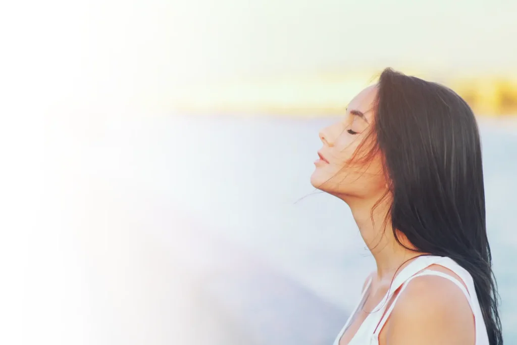 Side view profile portrait of a happy brunette woman relaxing breathing fresh air outdoors in summer Girl close eyes doing deep breath exercises. Positive emotion success, peace of mind, zen concept.